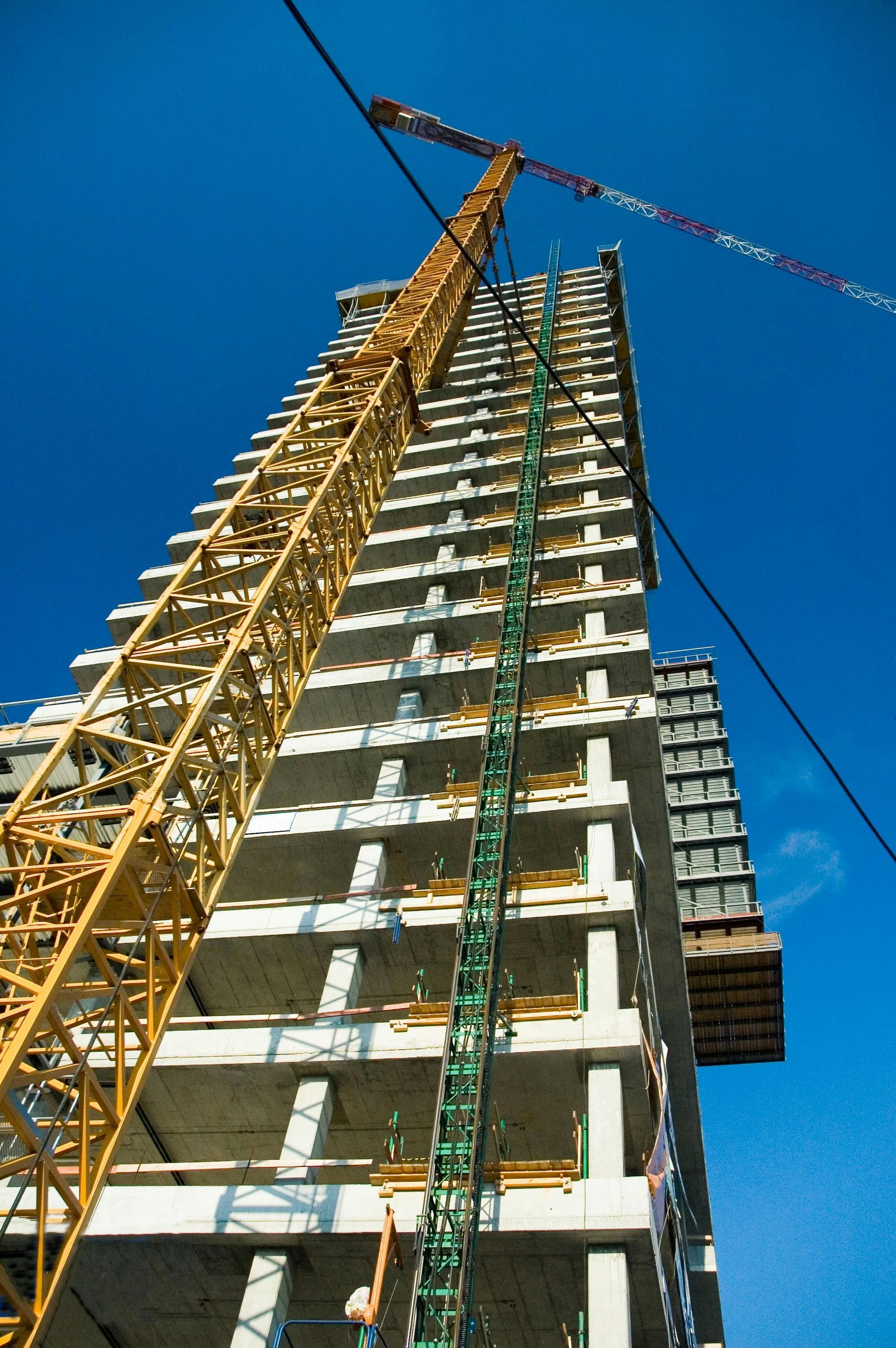 Looking up at a tall building under construction with a crane