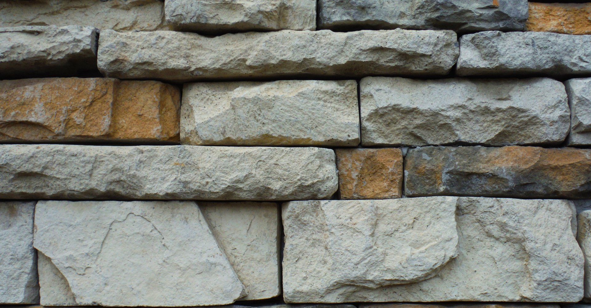 A close up of a brick wall made of different colored bricks.