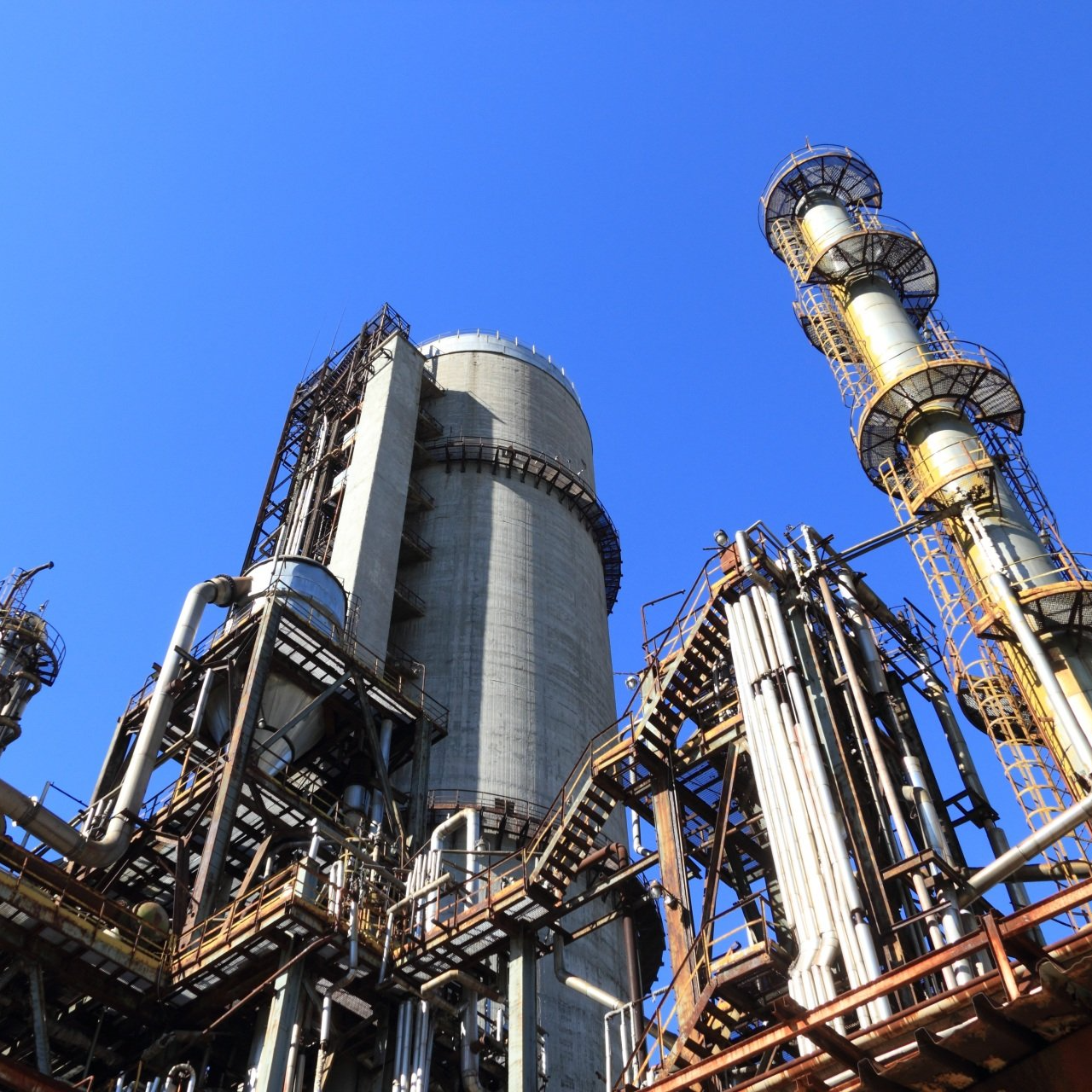 A large industrial plant with a blue sky in the background