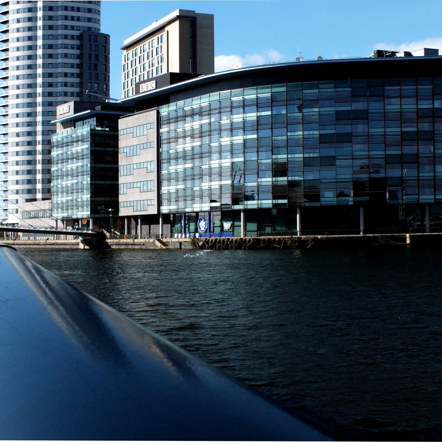 A large building with a lot of windows is next to a body of water