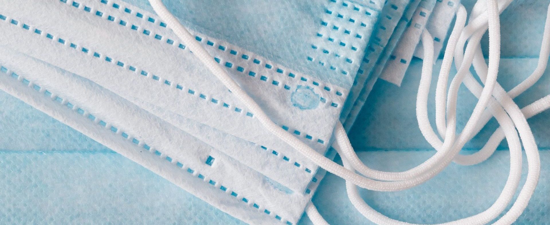 A close up of a stack of surgical masks on a table.