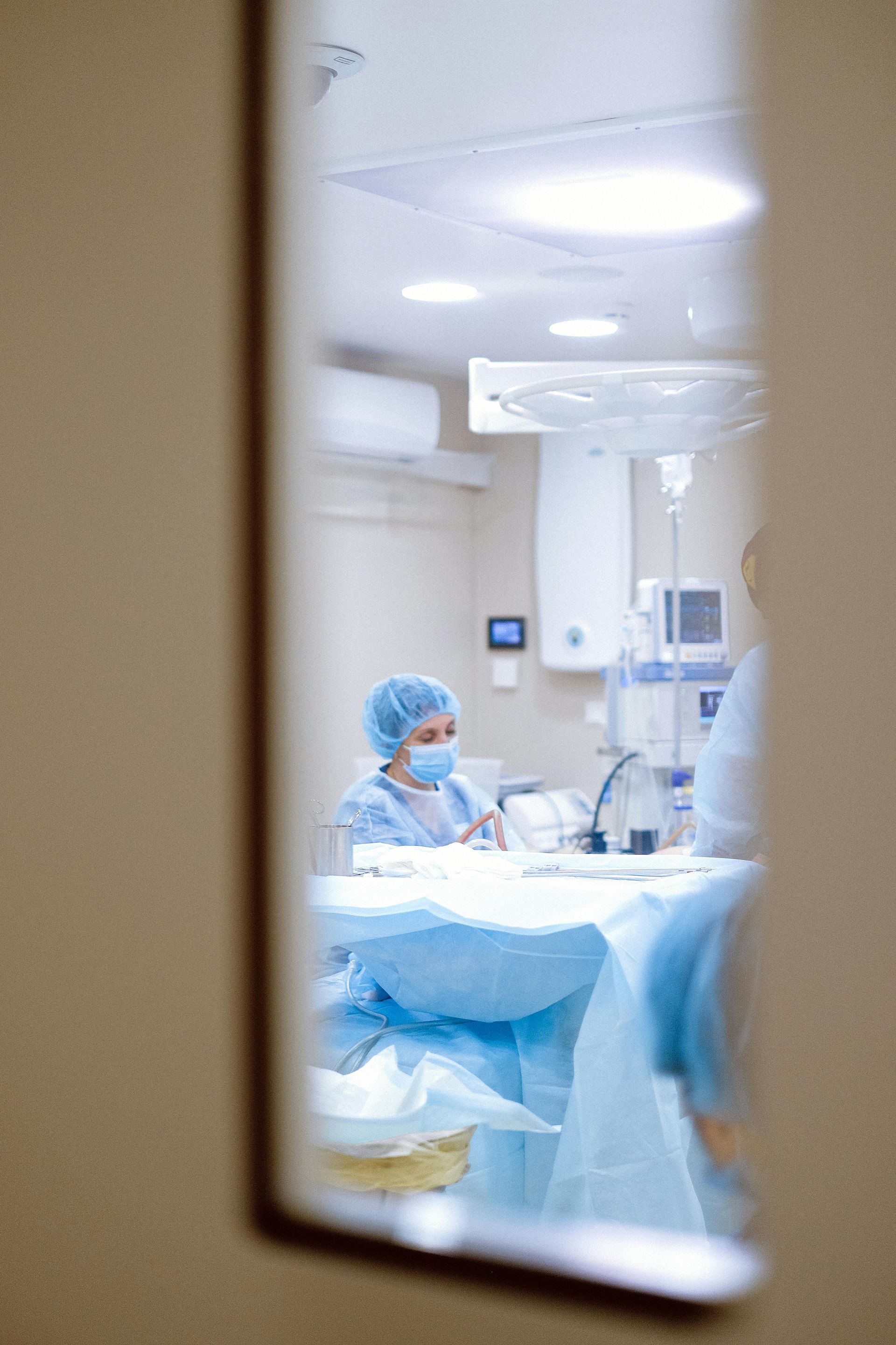 A surgeon is operating on a patient in an operating room.