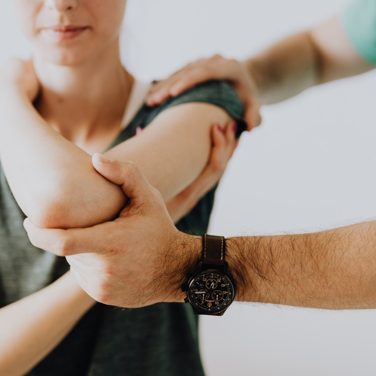 A man wearing a watch is holding a woman 's arm