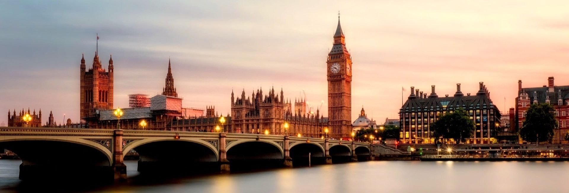 A bridge over a river in london with big ben in the background.