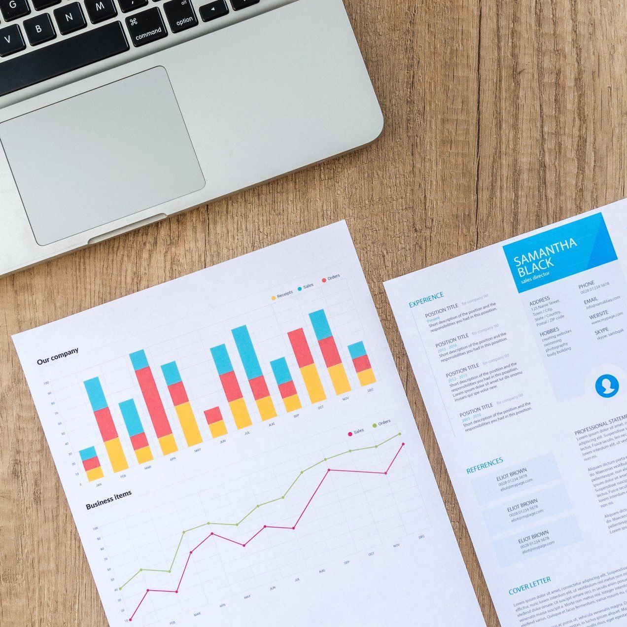 A resume and a graph are on a table next to a laptop