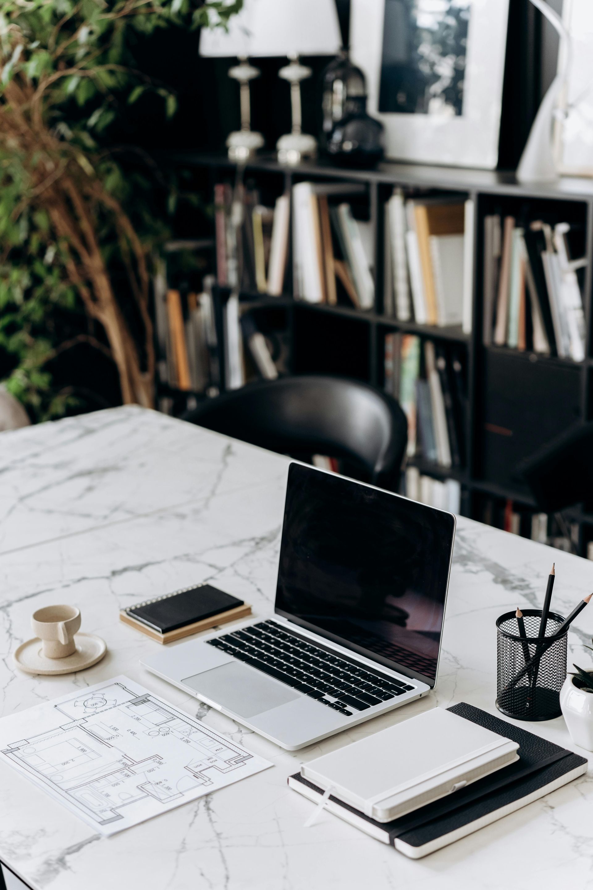 A laptop is sitting on a desk next to a cup of coffee.