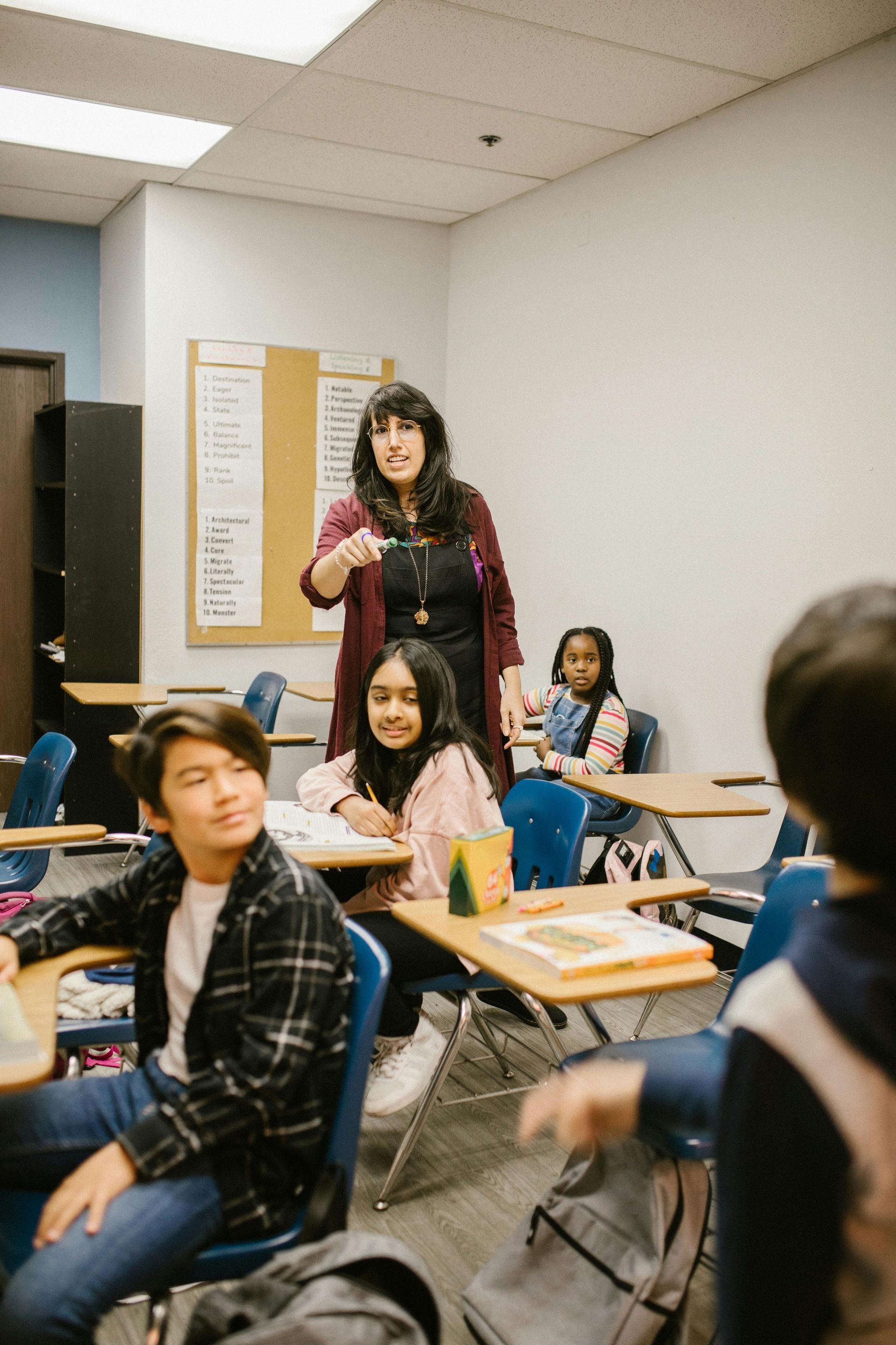 A teacher is standing in front of a classroom full of students.