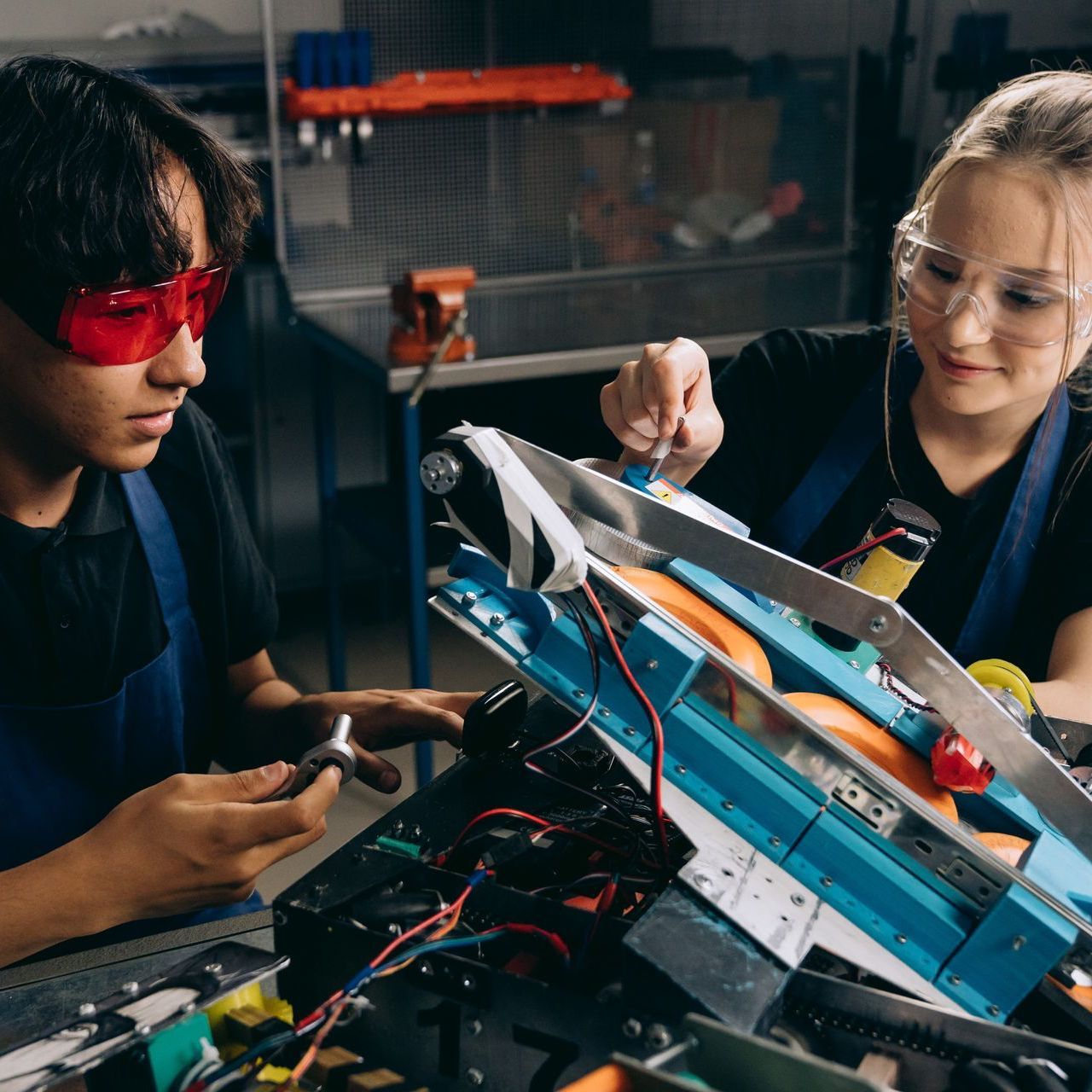 A man and a woman are working on a machine