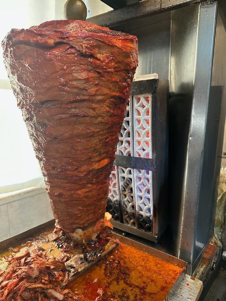 A large piece of meat is being cooked on a grill.