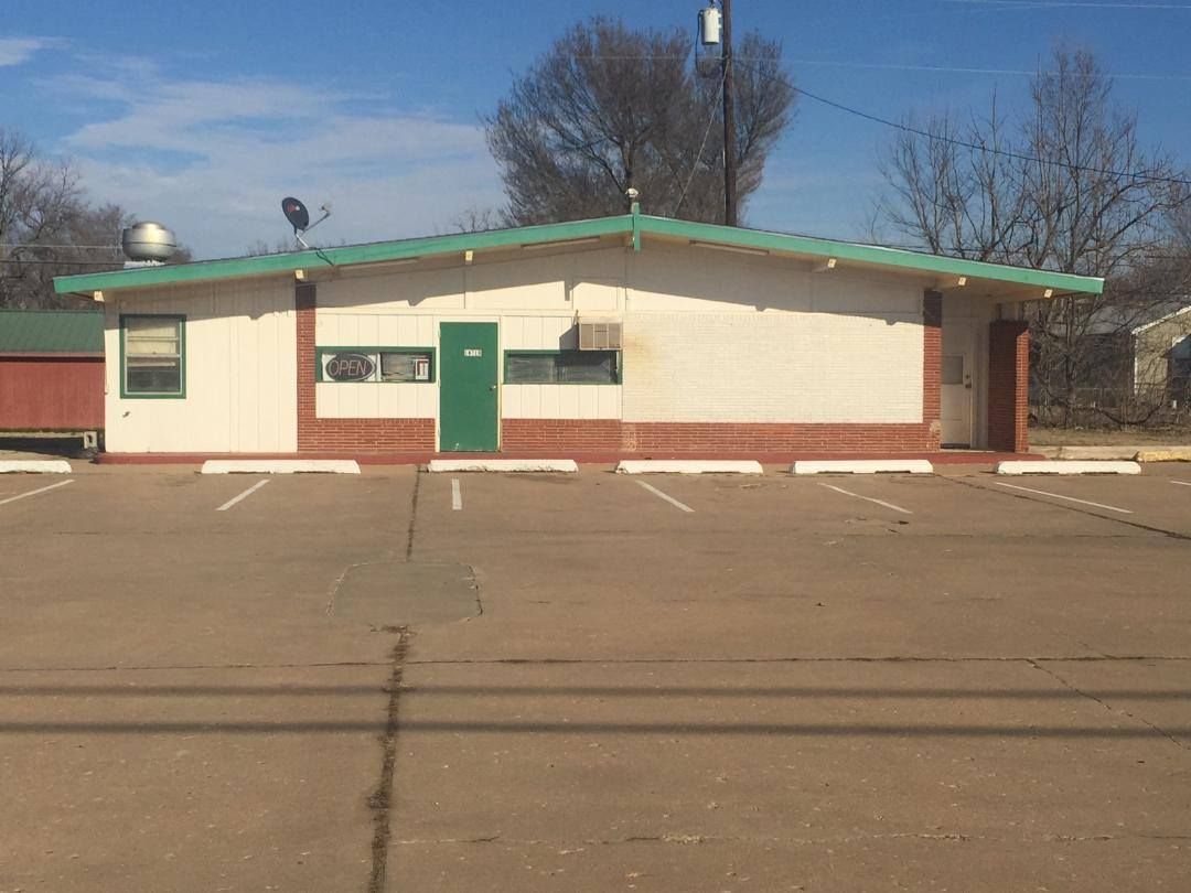 Juquila Tacos building with a green roof and a parking lot in front of it.