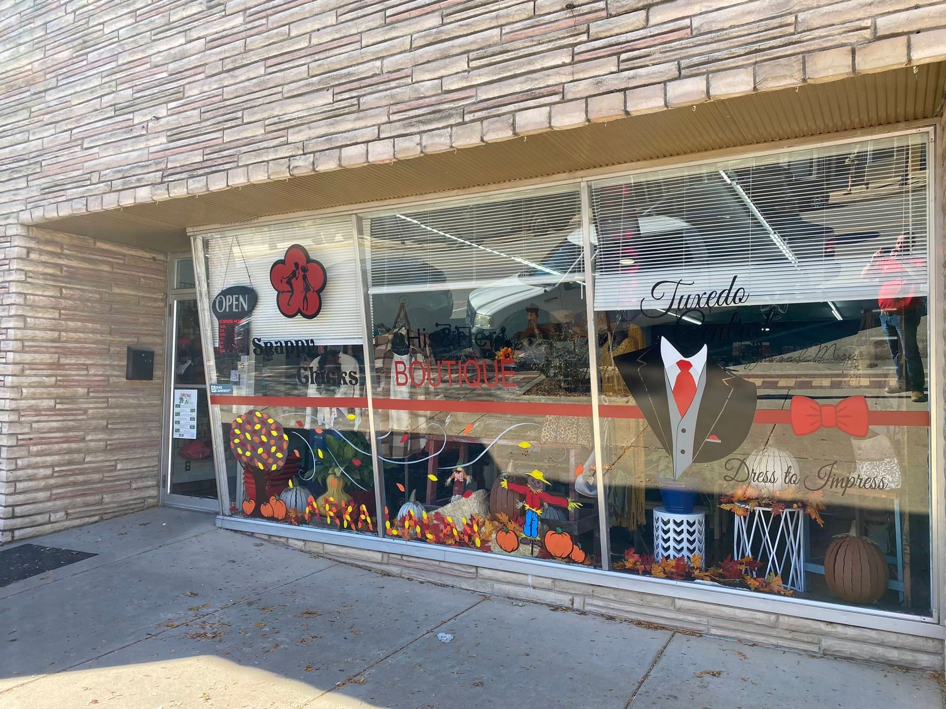 A store front with a tuxedo and tie on the window.