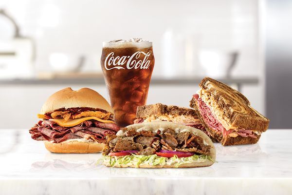 A table topped with sandwiches and a glass of coca cola.