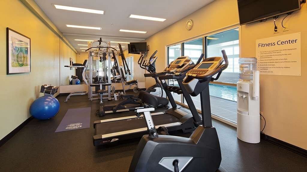 A gym with treadmills , bikes and a water cooler
