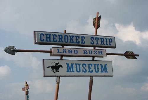 A sign for the cherokee strip land rush museum