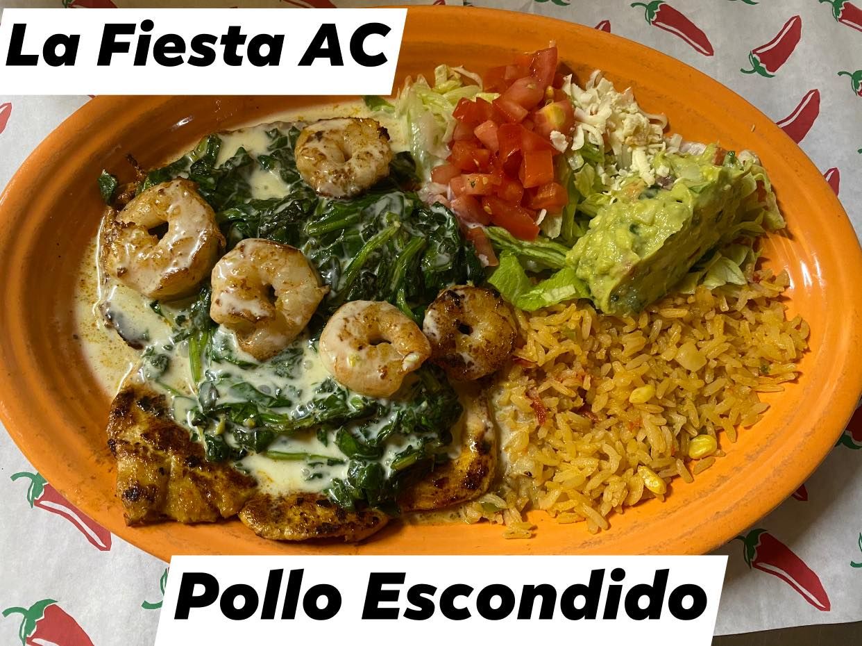 A plate of food with shrimp , spinach and rice on a table.