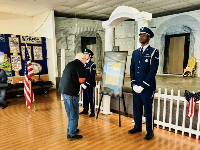 Photo Credit Amanda Stickel Evinger A man in a military uniform is talking to another man in a museum room.