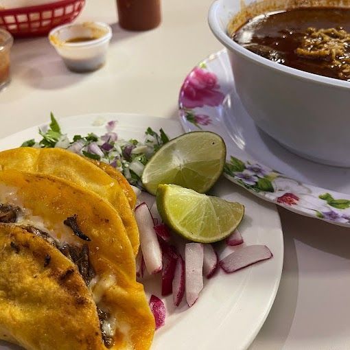 A plate of tacos next to a bowl of soup
