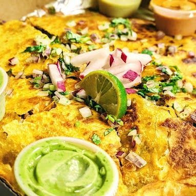 A close up of a pizza with sauces and a lime on top.