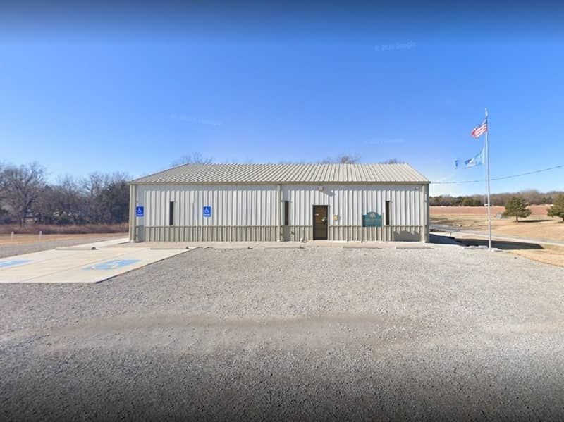 Agri-business building Ark City, KS A small community center building with a flag in front of it.