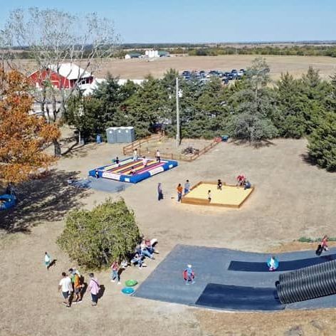 An aerial view of a pumpkin patch playground with people playing in it.