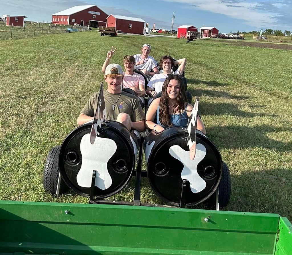 A group of people are enjoying a tractor ride in a field.
