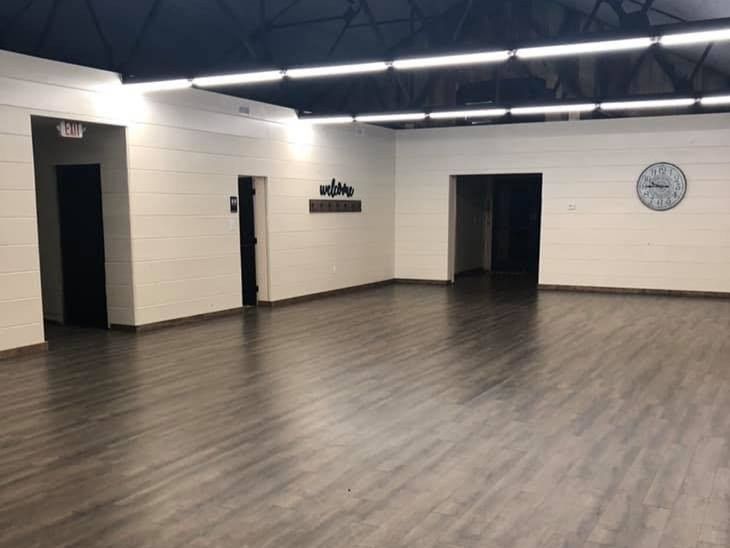 A large empty room with a clock on the wall.