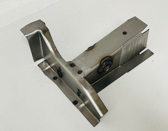 A bent metal automotive part with various cutouts and spot welds, likely for structural reinforcement.