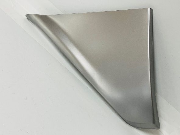 Metallic, triangular metal panel, with a curved edge, against a white background.