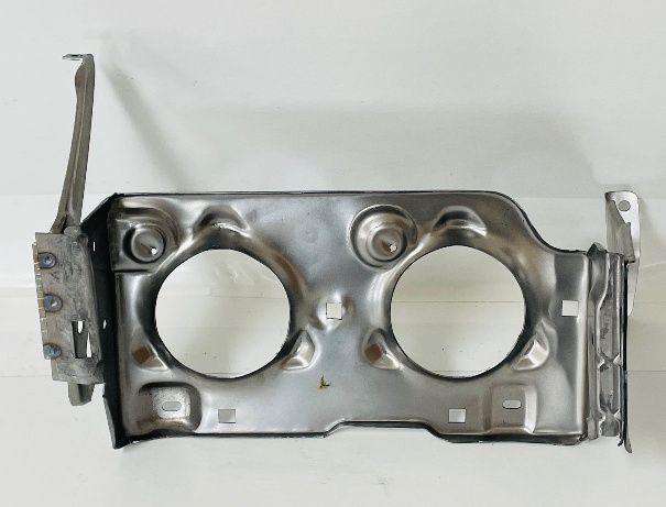 Metal headlight mounting bracket with two circular openings, various mounting points and brackets extending from the sides.