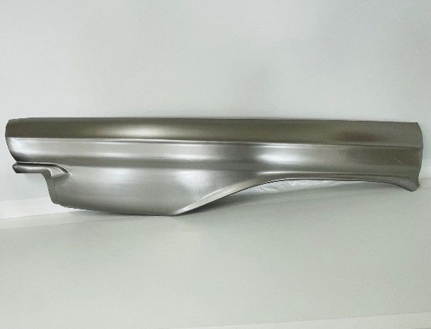 Metal car body panel, likely a fender, with curved edges and a smooth surface, lying on a white surface.