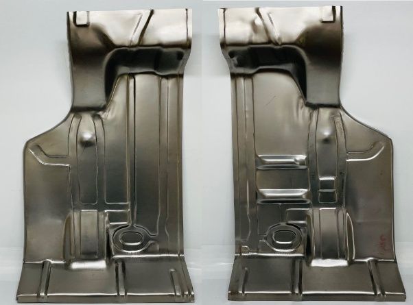 Two identical, silver-colored car floor pan stampings, side by side, ready for installation. They have intricate details and shapes.