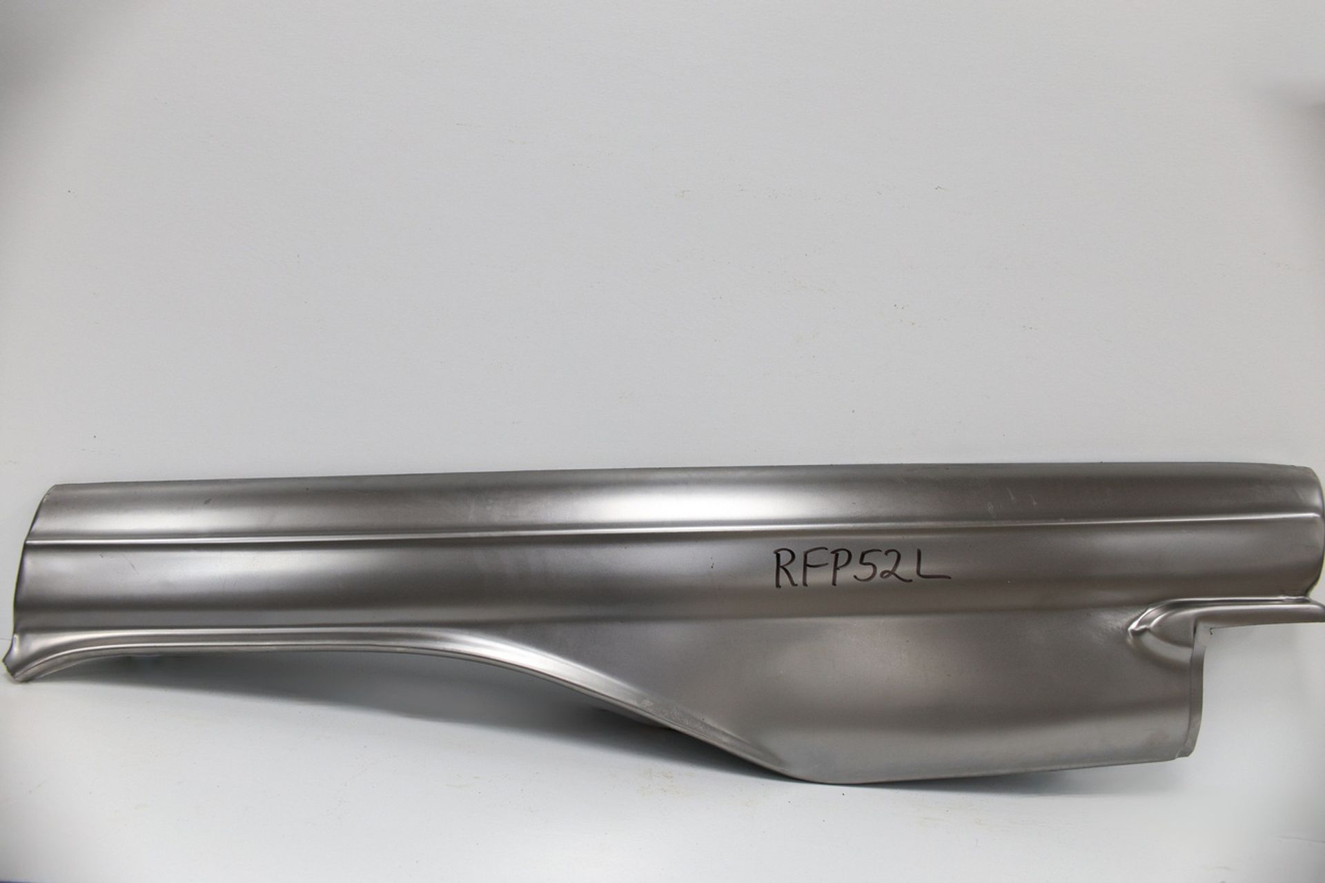 A piece of metal is sitting on a white surface.