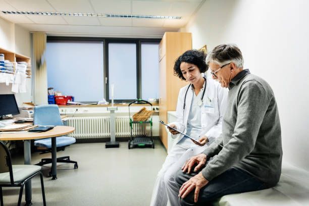 A doctor is talking to a patient in a hospital room.