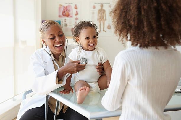A doctor is listening to a baby 's heartbeat with a stethoscope.