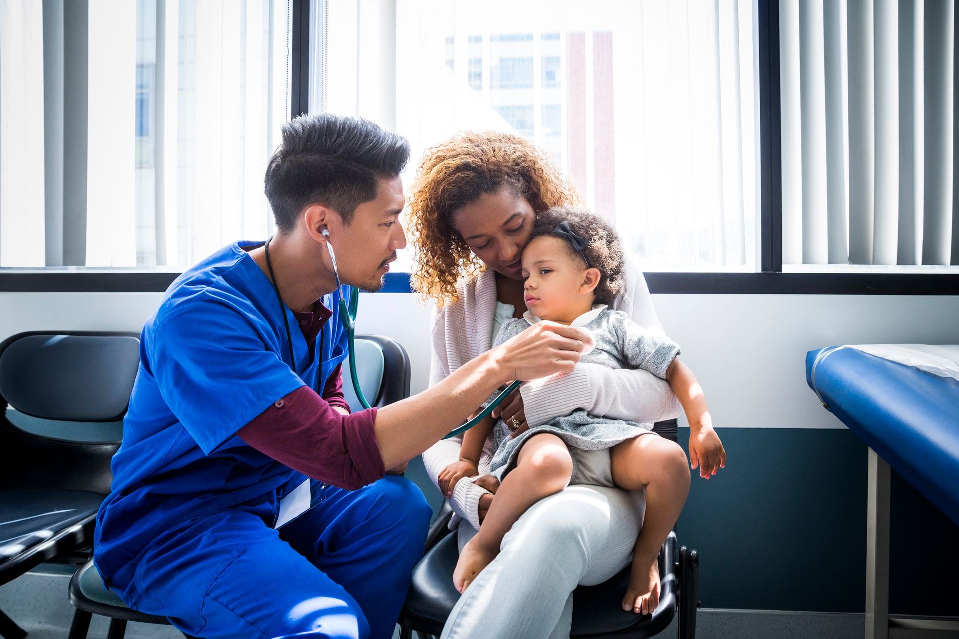 A doctor is listening to a child 's heartbeat with a stethoscope.
