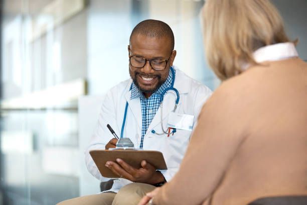 A doctor is talking to a patient while holding a clipboard.