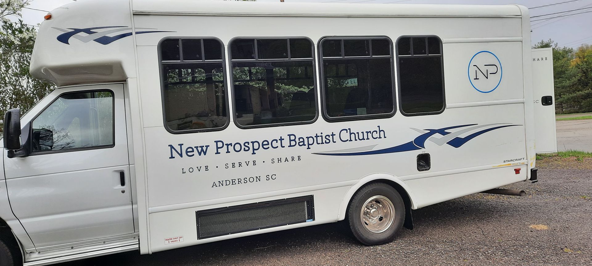 A white bus with new prospect baptist church written on it
