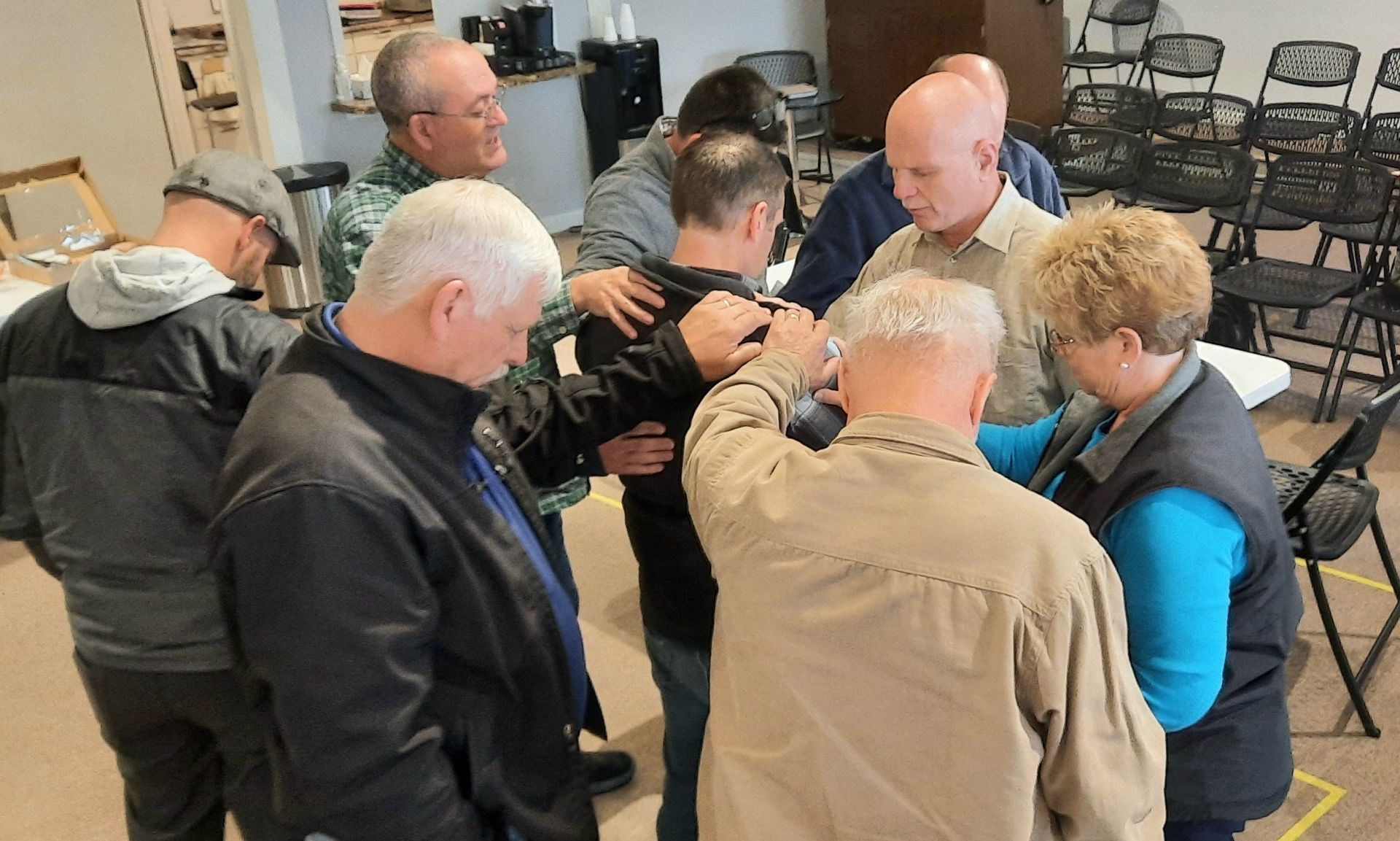 A group of people are praying together in a room.