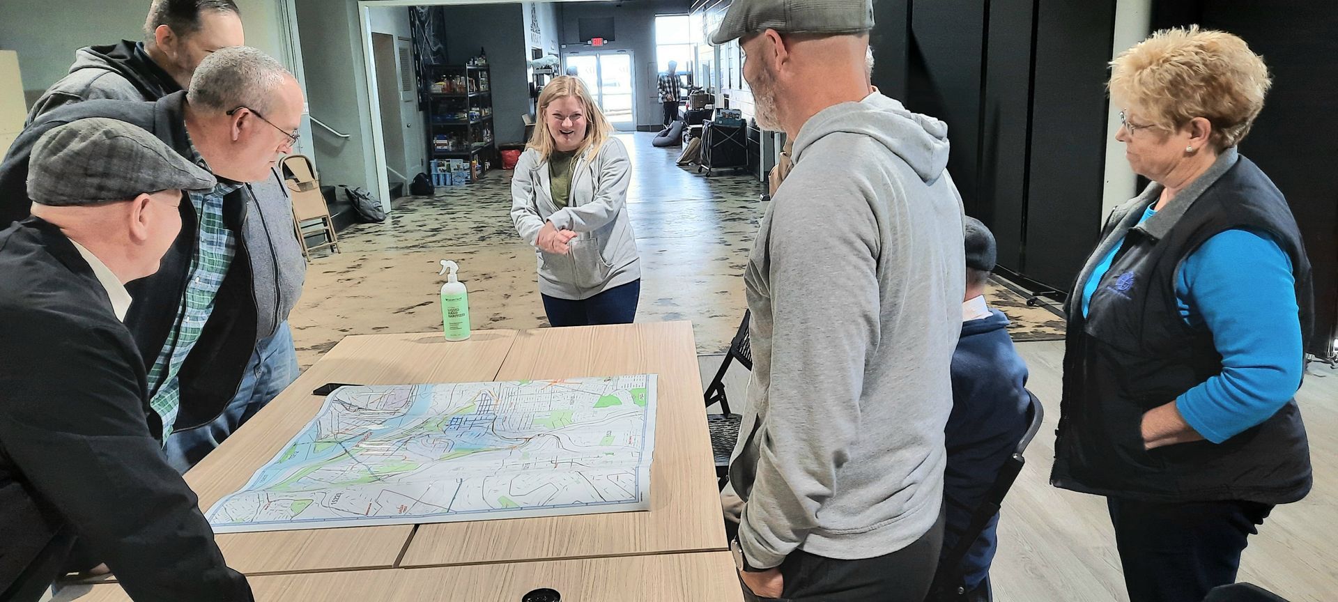 A group of people are standing around a table looking at a map.