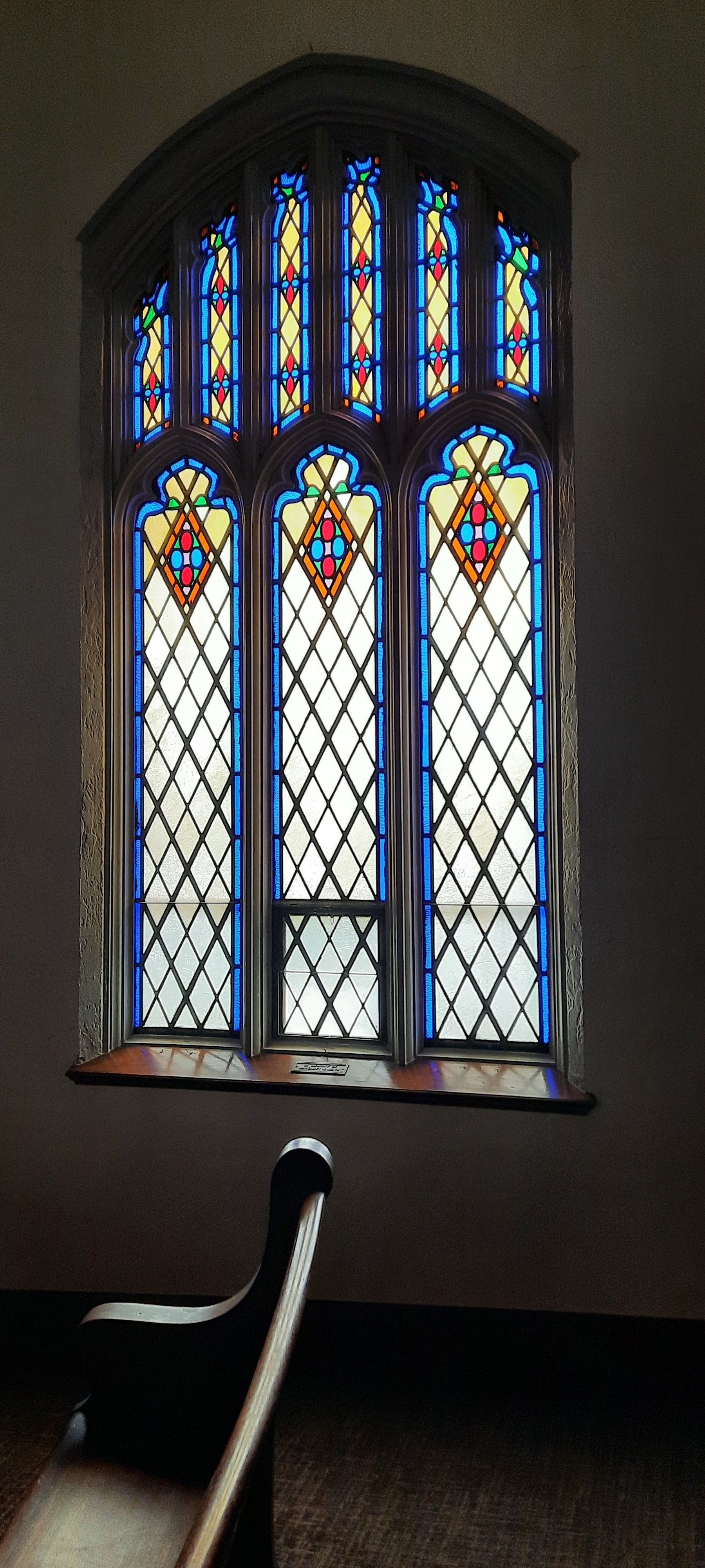 A stained glass window in a church with a coat of arms on it