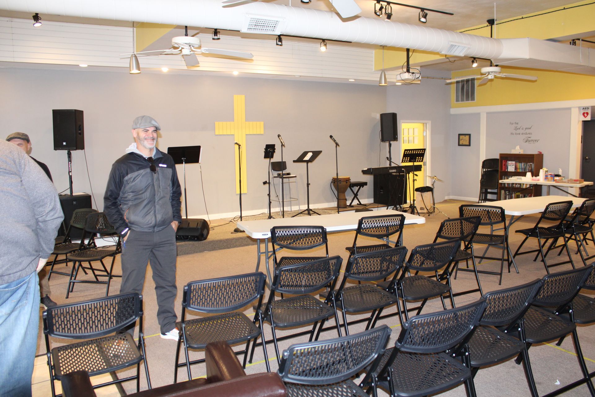 A man stands in a room with a cross on the wall