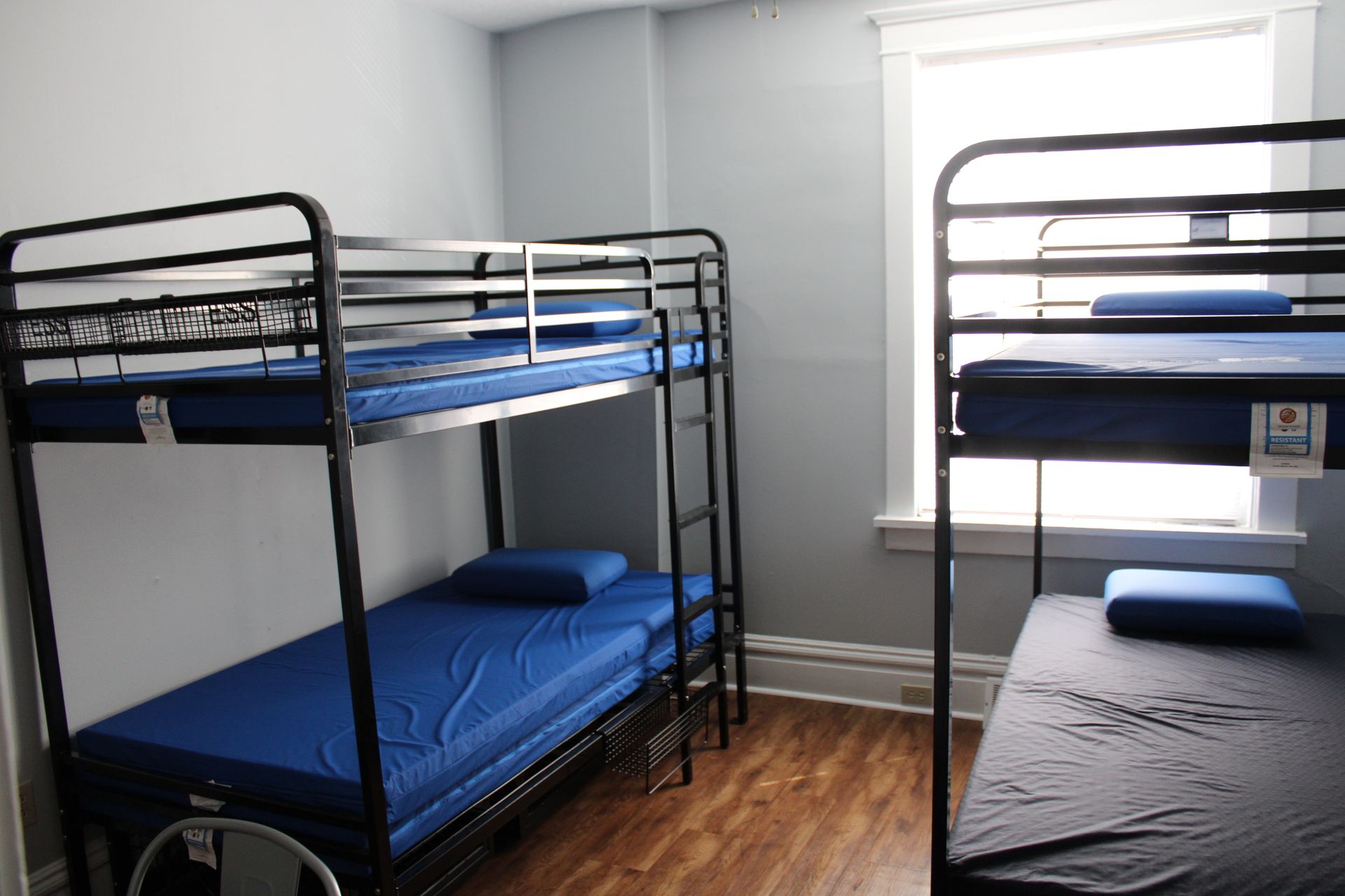 A room with three bunk beds and a window