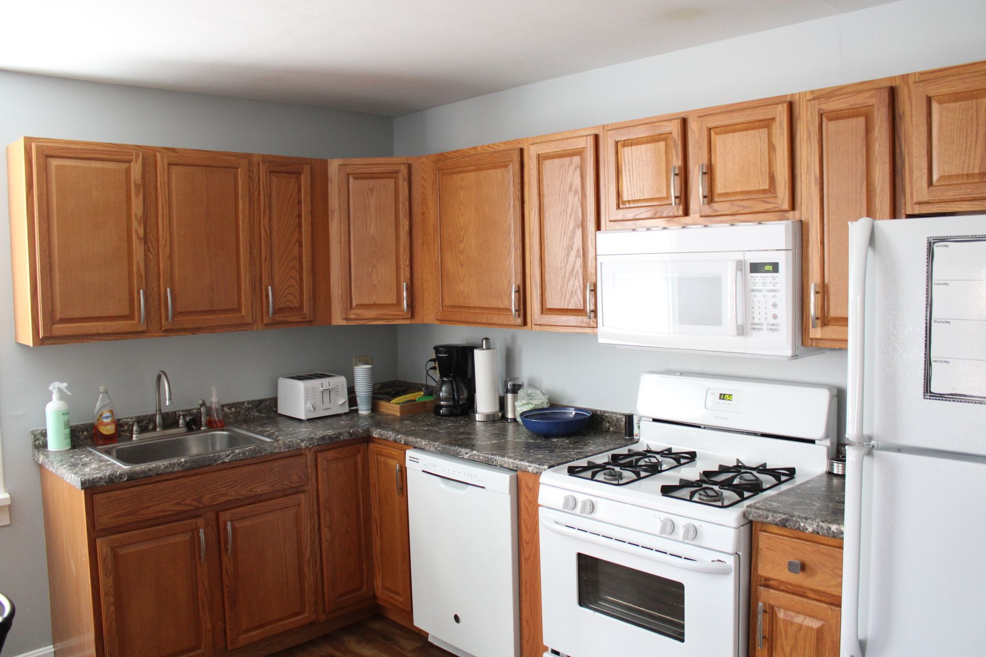 A kitchen with wooden cabinets and white appliances