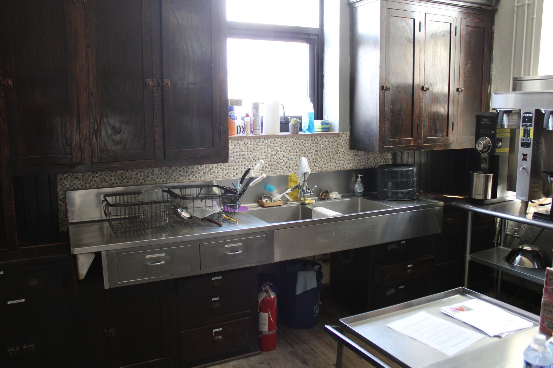 A kitchen with two sinks and a fire extinguisher