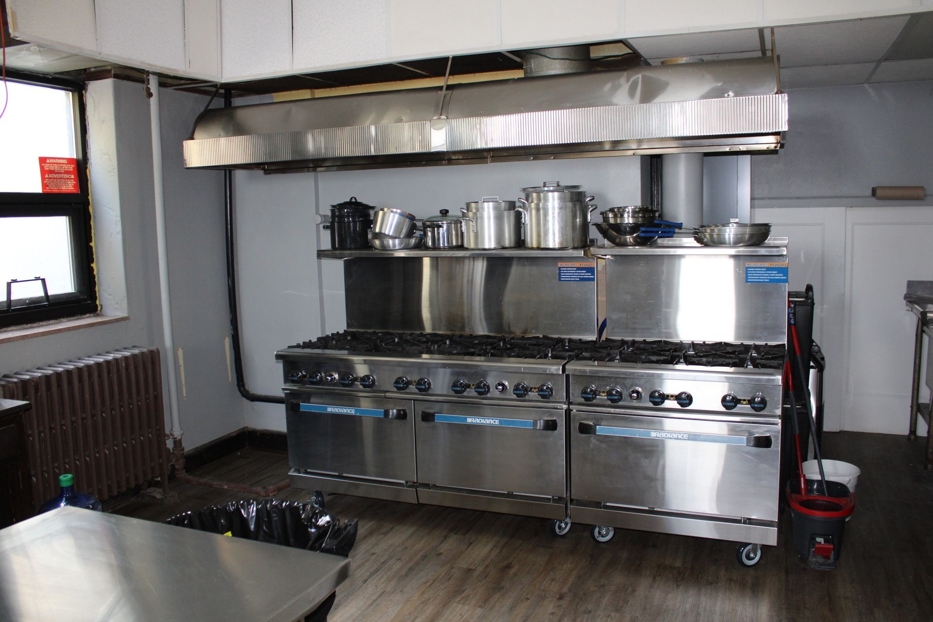 A kitchen with stainless steel appliances and pots and pans