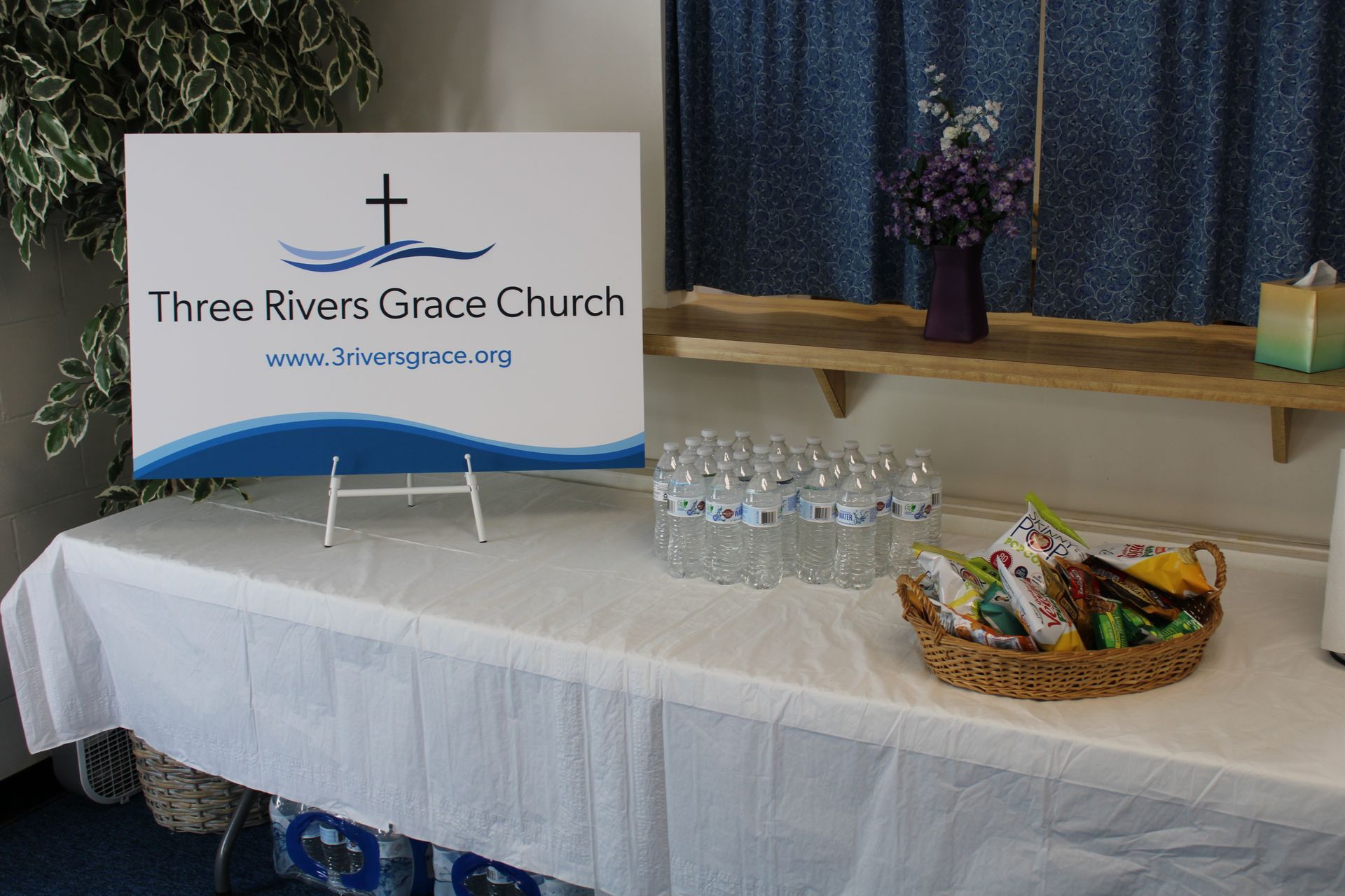A table with a sign that says three rivers grace church