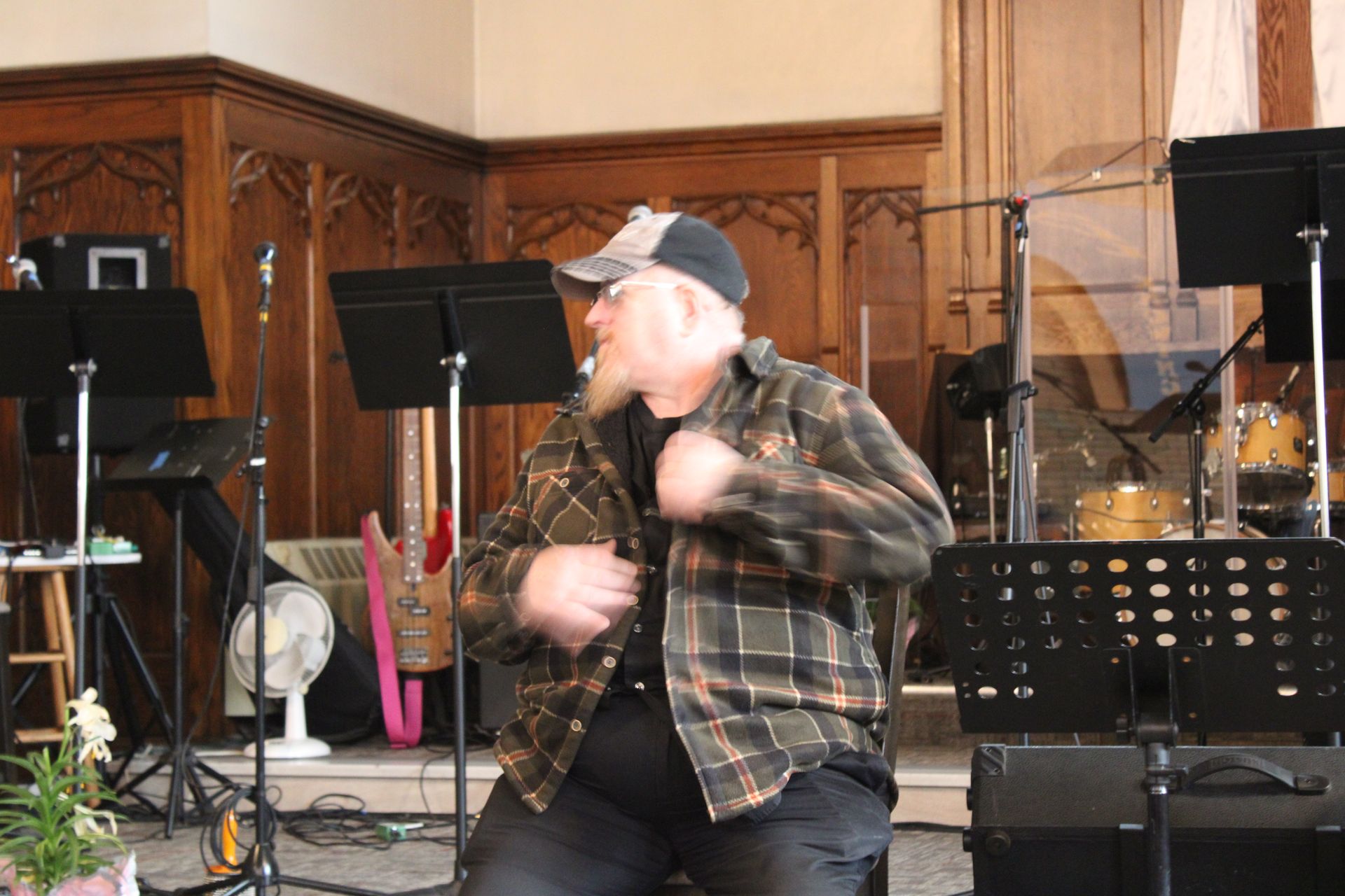A man in a plaid shirt is dancing on a stage