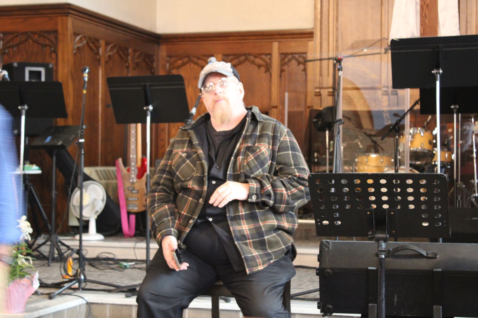 A man is sitting on a stool in front of a drum set
