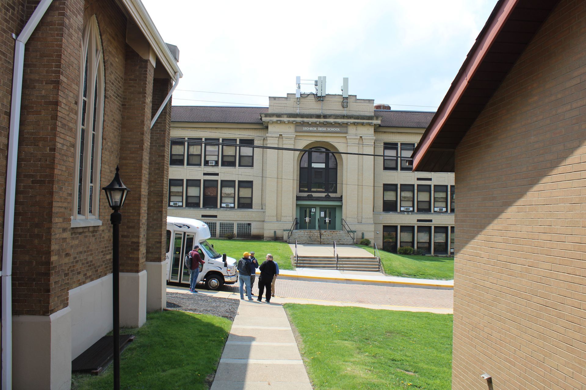 A group of people are walking down a sidewalk in front of a large building
