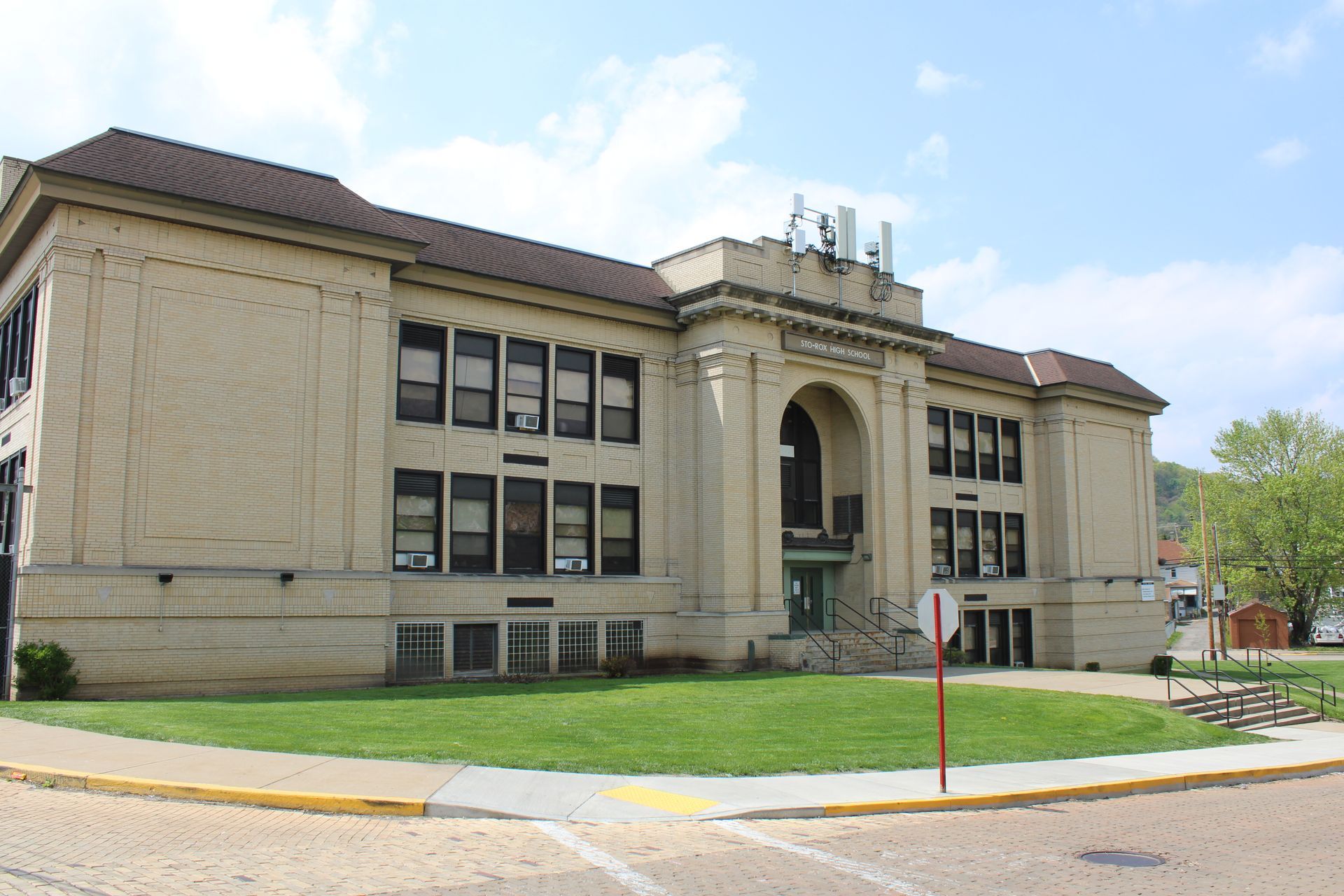 A large building with a lot of windows is sitting on top of a lush green field.